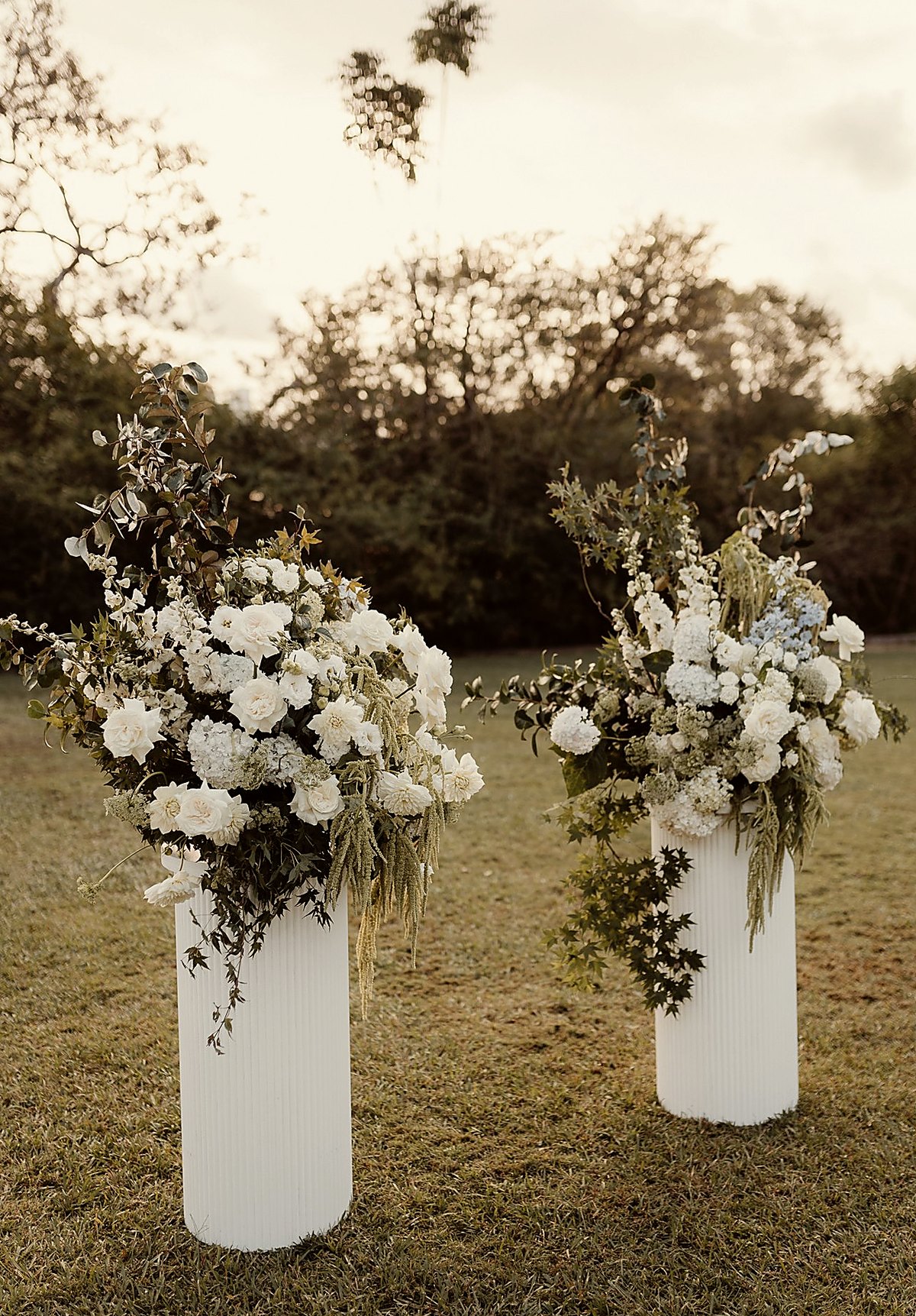Outdoor twin floral pedestals at golden hour